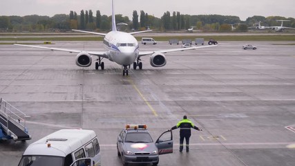 Ground Crew Worker Man Standing and Marshalling Directing an Aircraft on Arrival Show Position in Airport Area. People shows the direction the plane