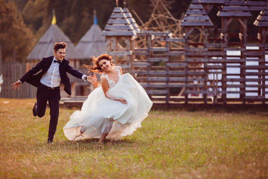 The beautiful brides running  along grass
