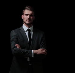 Handsome business man isolated on black with arms crossed