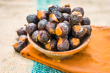 Close up of soap  nut .Sapindus in a clay bowl on a gunny bag.
