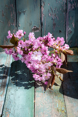 Fototapeta na wymiar Romantic Spring background with a vase of Japanese cherry blossoms on wooden table