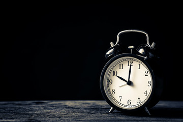 black retro alaemclock on old vintage wooden table with free copyspace for your text