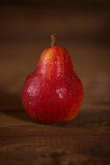 Pear red color on wooden background.