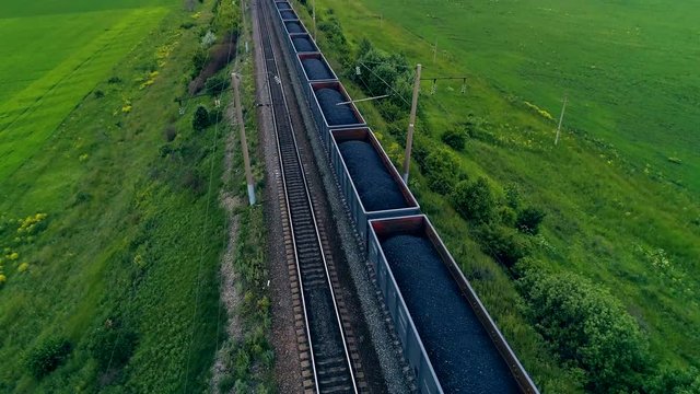 Big cargo train transporting coal. Aerial shot. Close-up.