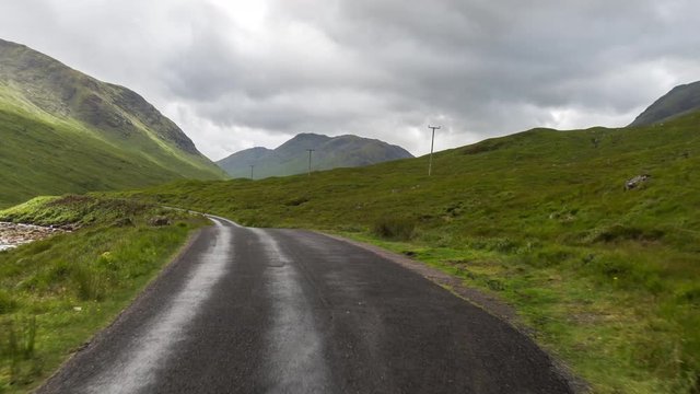 hyperlaspe POV shot from a camera attached to the front of a vehicle driving through beautiful empty roads in the scottish highlands