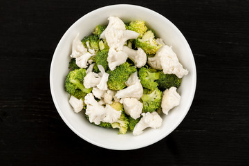 Fresh salad with raw broccoli and cauliflower in a white dish
