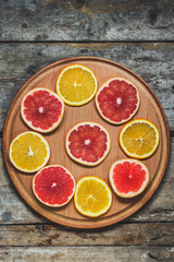 slices of different varieties of citrus fruits on the table (background)