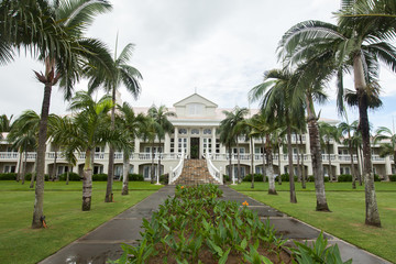 Fototapeta na wymiar Luxury house in Mauritius, with a green lawn and palm trees.