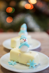 Christmas dessert with snowman on lights bokeh background