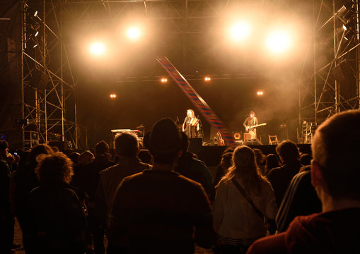 People silhouettes in front of bright stage lights, music