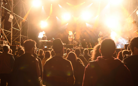 People silhouettes in front of bright stage lights,