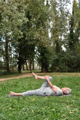 elderly woman practicing yoga outdoors