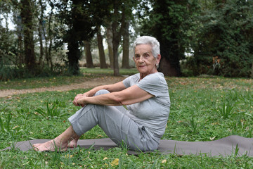 Naklejka na ściany i meble elderly woman practicing yoga outdoors