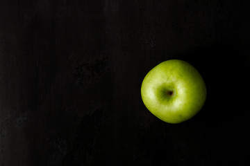 Green apple on a black background.