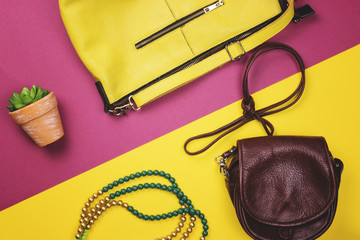 Bag, flowers and other womens accessories by color and the bright background. The view from the top. Flat lay.