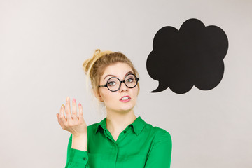 Woman holding black thinking bubble