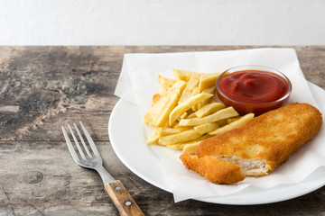 Traditional British fish and chips on wooden table. Copyspace