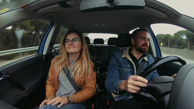 Funny, Cute And Adorable Milennial Hipster Couple Do Small Dance Inside Car, Shot On Action Wide Angle Camera, Smile, Ready For Adventure Or Road Trip Holiday In Winter