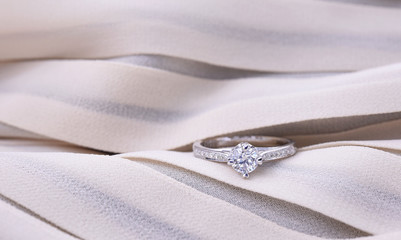 Diamond ring on silk texture , wedding ring romantic.   - obrazy, fototapety, plakaty