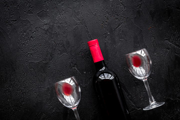 Drink red wine. Bottle and glass on black background top view copyspace