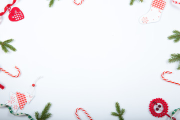 Christmas holiday composition. Festive creative red pattern, xmas handmade decor holiday with ribbon, candy canes, gift, christmas tree and decorations on white background. Flat lay, top view