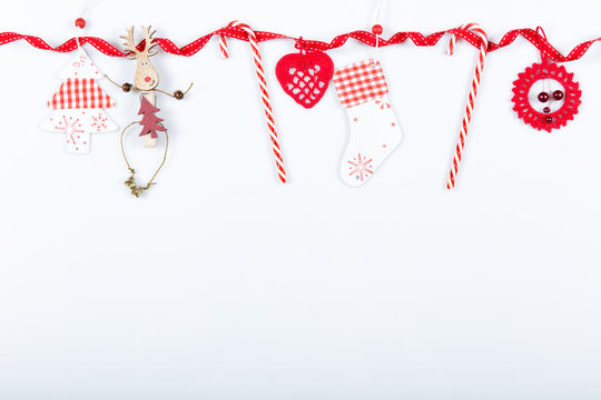 Christmas holiday composition. Festive creative red pattern, xmas handmade decor holiday with ribbon, candy canes, gift, christmas tree and decorations on white background. Flat lay, top view
