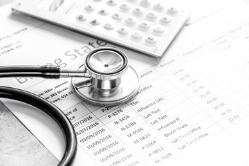 health care billing statement with doctor's stethoscope on stone