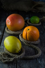 Citrus fruit orange lemon grapefruit and lime on the old wooden background