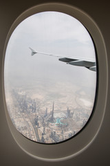 The plane-the view from the window of the porthole on the city Arab Emirates Dubai