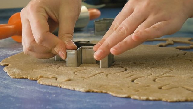 Woman cutting cookies in dough, extreme closeup dolly shot color graded