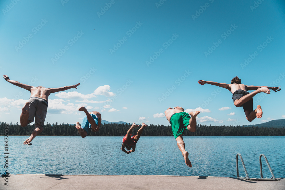 Wall mural 5 guys jumping in lake in a flying v.