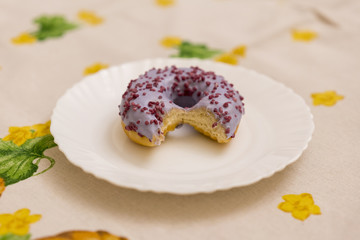 Bitten strawberry donut with colorful sprinkles