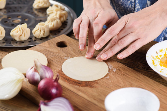 Cooking healthy vegetarian dish. Woman hands making steam dumplings momo
