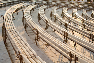 Fototapeta premium Row of wooden benches at summer theater in a city park.