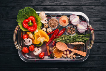 Assortment of vegetables, herbs and spices for cooking. Top view. On a wooden surface. Free space for text.