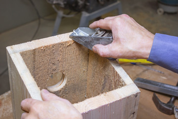 Processing of details of a wooden birdhouse