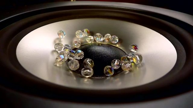 Closeup at moving sub-woofer. Speaker part. Throws up precious crystals of cut glass. Super slow motion close-up shot