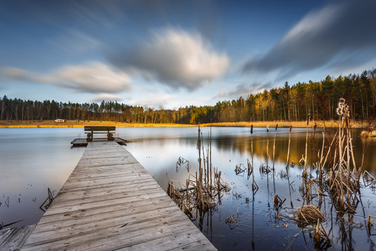 Small woody fishing pier at the lake.