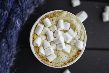 A cup of coffee with marshmallows and a warm blanket. - 184731335