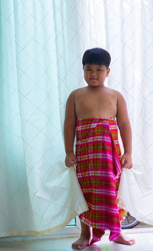 The boy wears a colorful fabric pattern.