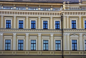 Fototapeta na wymiar множество окон на серо коричневом фасаде большого дома