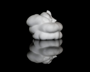 White shaving lather foam on top of a reflective glass surface, isolated on black