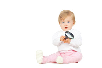 Caucasian baby girl holding magnifying glass isolated on white background