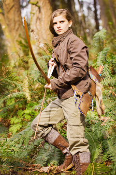 A young girl ready to hunt with her bow and arrow.