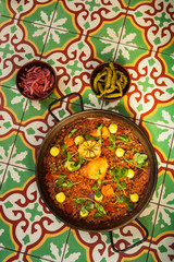 chorizo and pollo paella on tile tabletop
