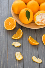 Plate with fresh ripe oranges on wooden table
