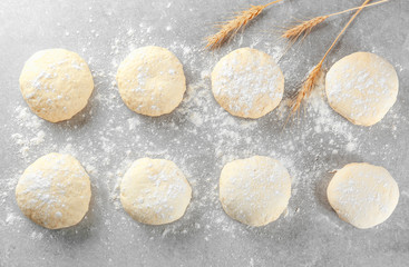 Raw dough balls with flour on table
