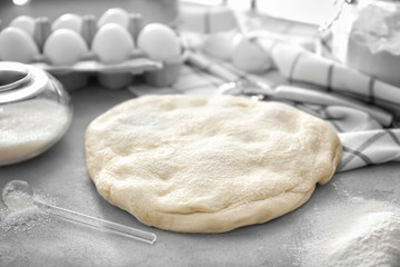 Raw flaky dough on kitchen table