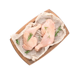 Wooden board with raw chicken legs on white background