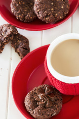 Chocolate oats cookies with chocolate-nuts spread and cup of coffee. Christmas concept. White wooden background. Top view.